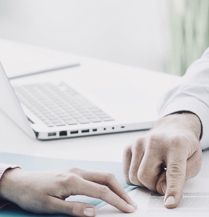 Main d'un collaborateur sur un bureau de travail